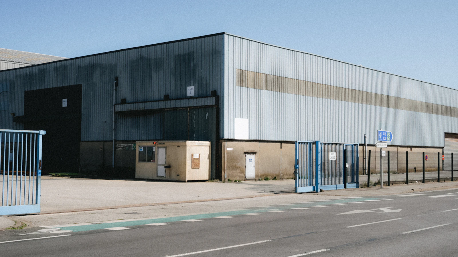 Large commercial warehouse entrance with secure blue gates