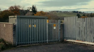 Metal security gate fitted beside a brick boundary wall